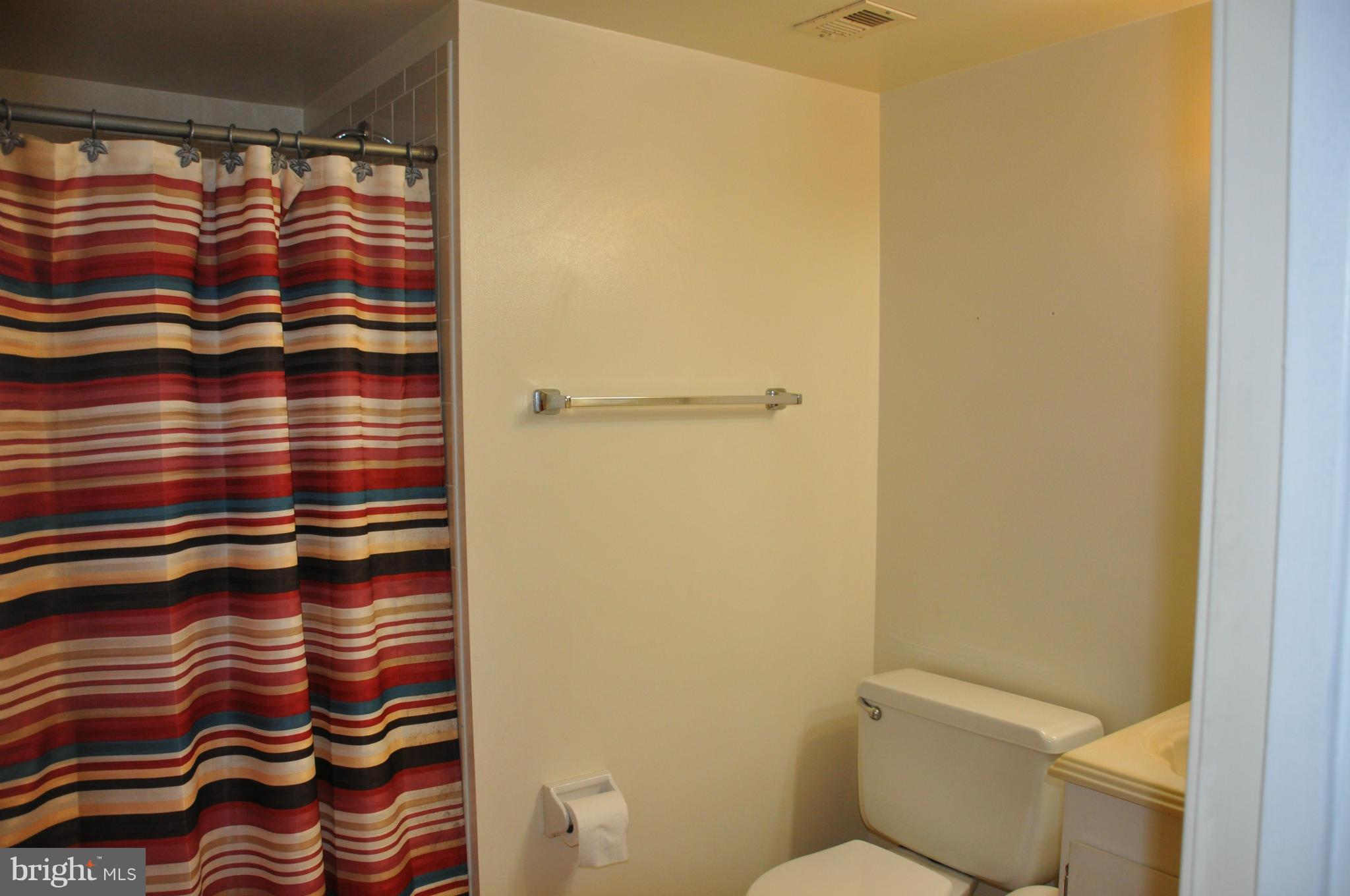 7938 Spring Forest Court, Unit 7938 Springfield, VA 22152 - Photo 21 of 29 a bathroom with a shower curtain and a toilet