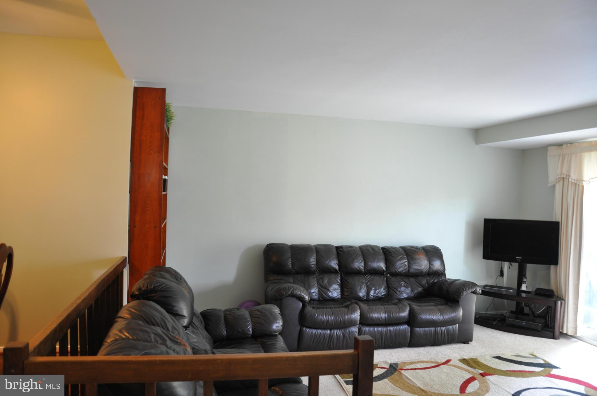 7938 Spring Forest Court, Unit 7938 Springfield, VA 22152 - Photo 6 of 29 a living room with furniture and a flat screen tv