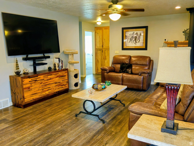 802 East 3200 Road North Preston, ID 83263 - Photo 31 of 59 Spacious living area featuring wood-finish flooring, a stone fireplace with a wood mantle, and light gray wall paint