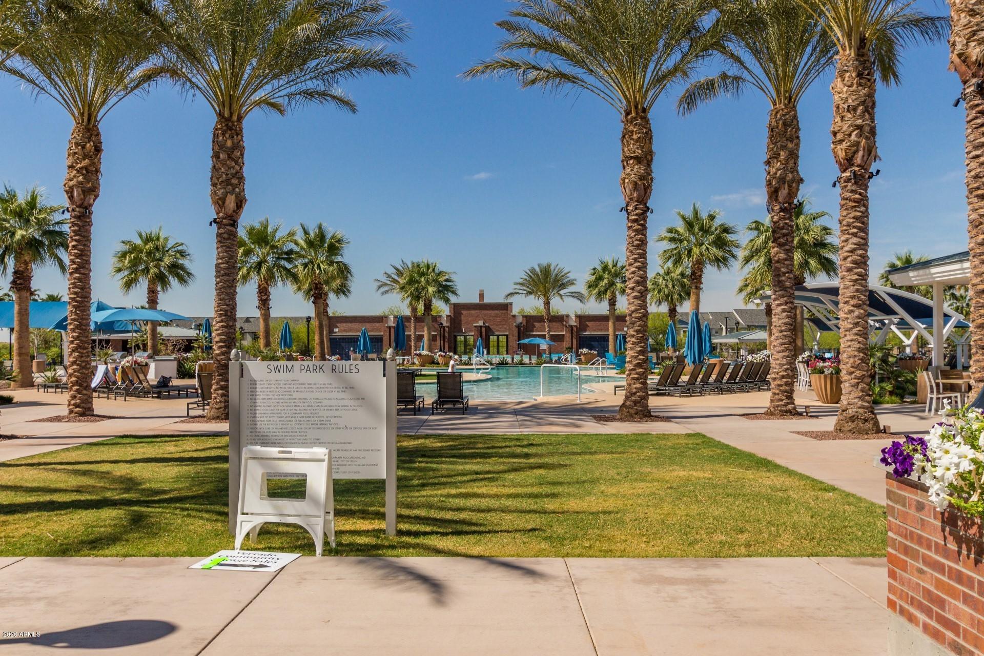 4280 North Verrado Way Buckeye, AZ 85396 - Photo 27 of 41 a view of a swimming pool with a lawn chairs under palm trees
