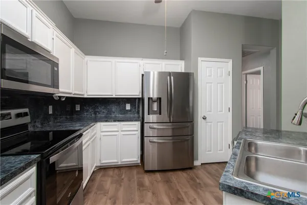 a kitchen with a refrigerator stove and sink