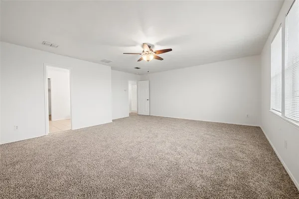 an empty room with fan and windows