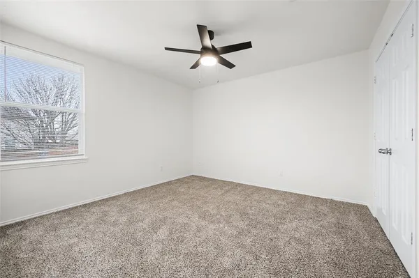 a view of empty room with ceiling fan