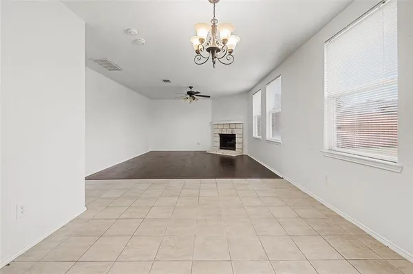 a view of empty room with a windows and chandelier