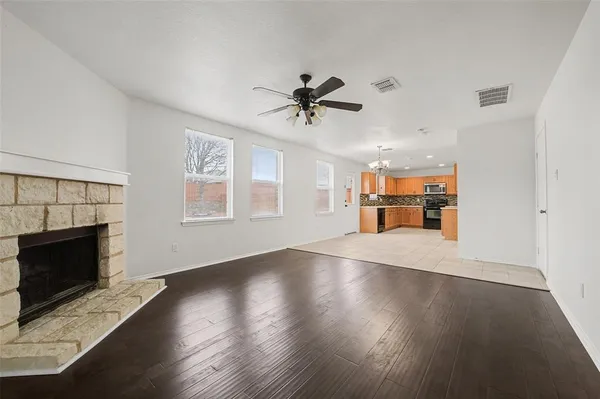 a view of empty room with wooden floor and fireplace