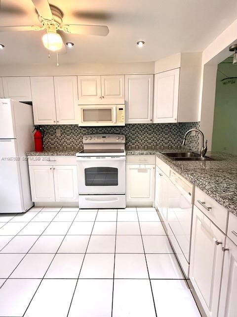 3910 Inverrary Boulevard, Unit 407B Lauderhill, FL 33319 - Photo 6 of 28 a kitchen with granite countertop a stove a sink and a refrigerator