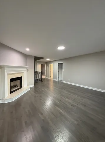 an empty room with wooden floor and fireplace