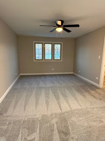 a view of empty room with window and ceiling fan