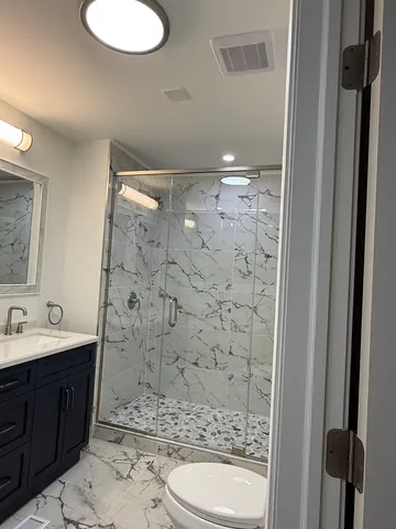 a bathroom with a double vanity sink mirror and shower