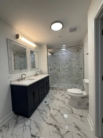 a bathroom with a double vanity sink mirror and toilet