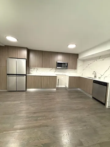 a view of empty room with wooden floor and window