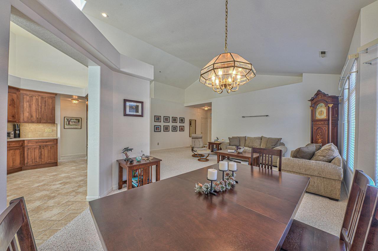 17644 River Run Road Salinas, CA 93908 - Photo 12 of 41 a dining room with wooden floor a chandelier a glass table and chairs