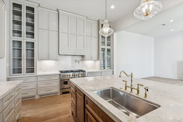 a kitchen with stainless steel appliances white cabinets and a stove top oven