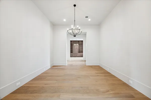 a view of a hallway with wooden shelves and a window