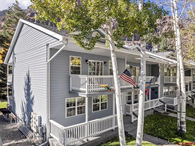 a front view of a house with a tree
