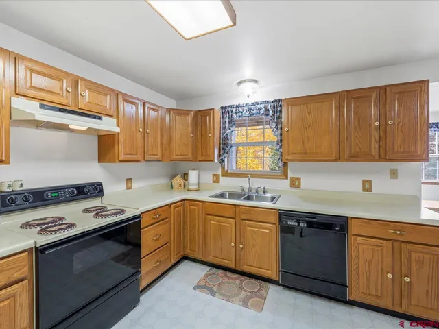a kitchen with a sink stove top oven and cabinets