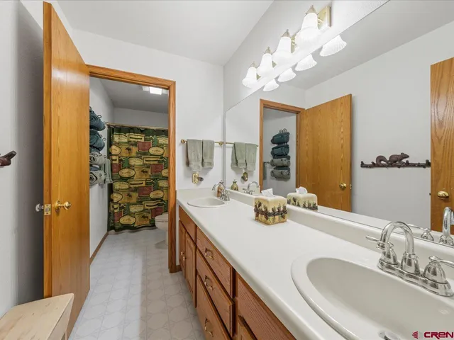 a en suite bathroom with a double vanity sink mirror and shower