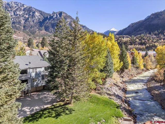 a view of a house with a yard and mountains
