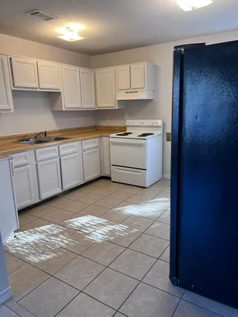 a kitchen with stainless steel appliances granite countertop a sink a stove a refrigerator and cabinets