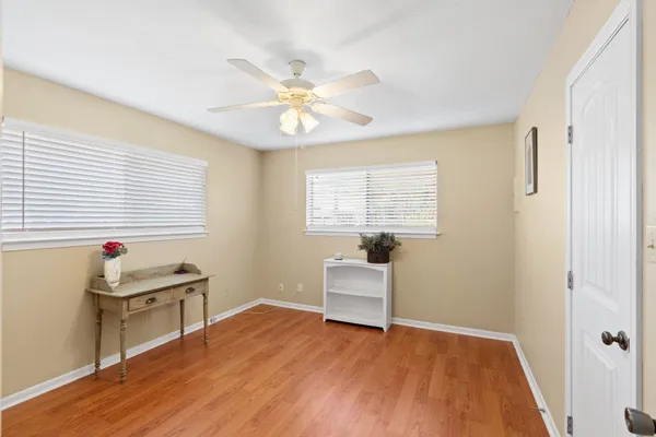 a view of an empty room with wooden floor and a potted plant
