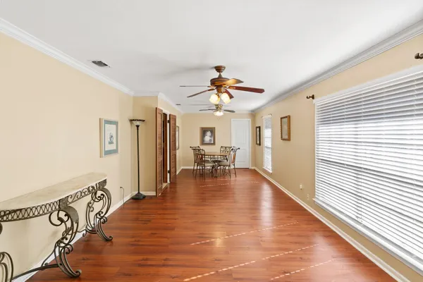 a view of a livingroom with furniture chandelier fan and wooden floor