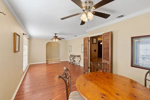 a view of a livingroom with wooden floor and a ceiling fan