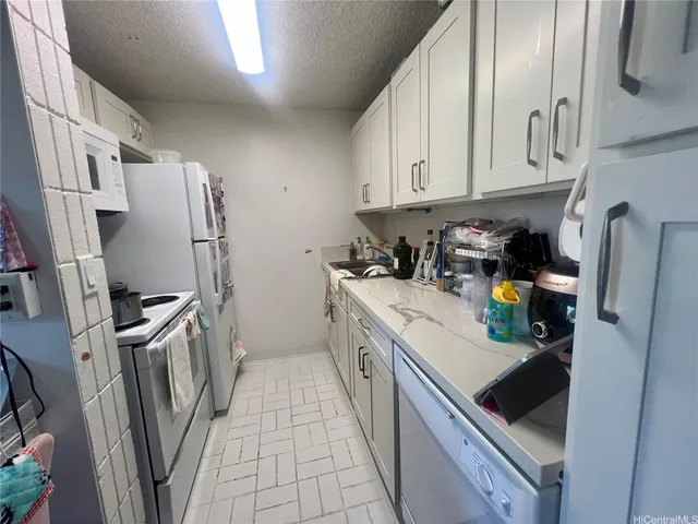 a kitchen with stainless steel appliances granite countertop a refrigerator a stove and a sink