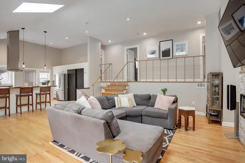a living room with furniture a flat screen tv and a large window