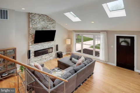 a living room with wooden floor and a flat screen tv