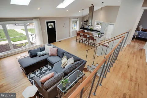 a view of a hallway with wooden floor and stairs