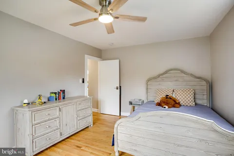 a bedroom with a dresser and a chandelier