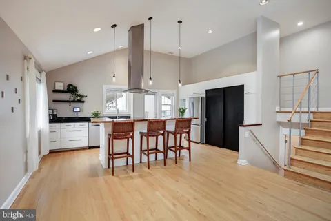 a kitchen with stainless steel appliances kitchen island granite countertop a refrigerator a stove a sink dishwasher with a dining table and chairs