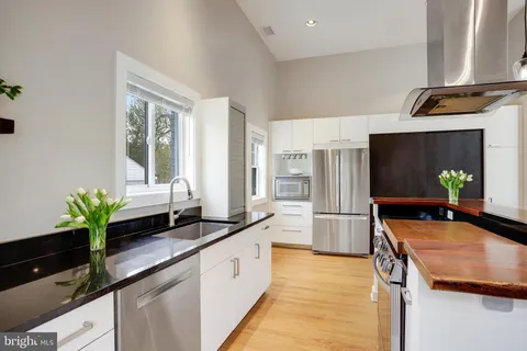 a kitchen with stainless steel appliances a stove a sink and a refrigerator