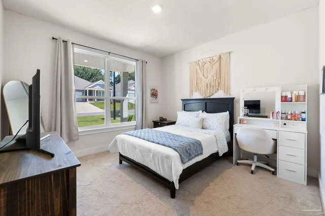 a bedroom with a bed a bookshelf a mirror and a large window