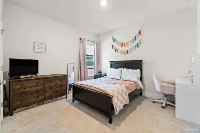 a spacious bedroom with a bed and a flat screen tv