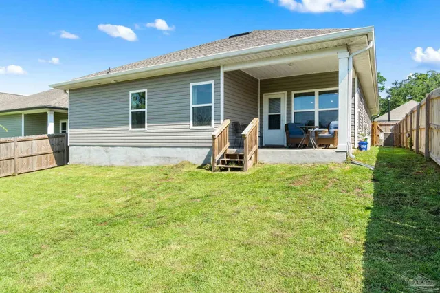 a view of a backyard with table and chairs and wooden fence