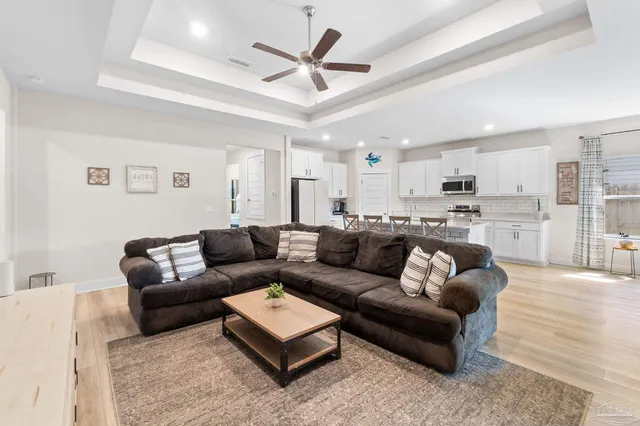 a living room with furniture kitchen view and a chandelier