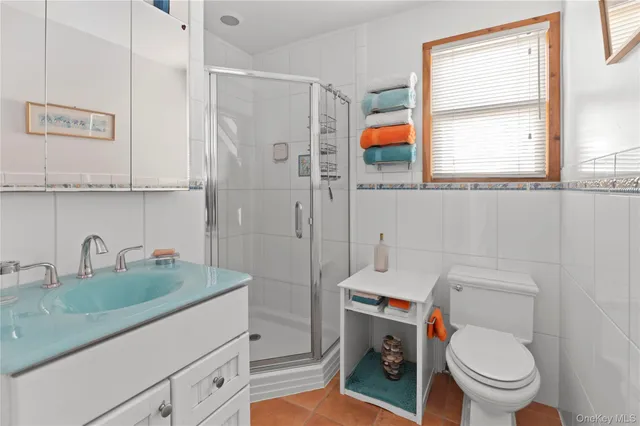 a bathroom with a granite countertop toilet sink and mirror