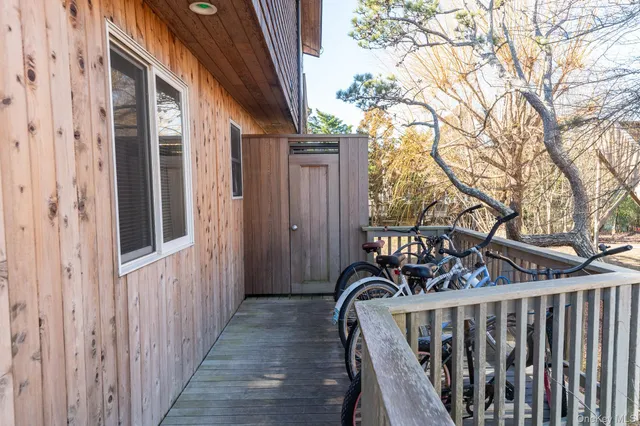 a view of a patio with table and chairs potted plants with wooden floor and fence