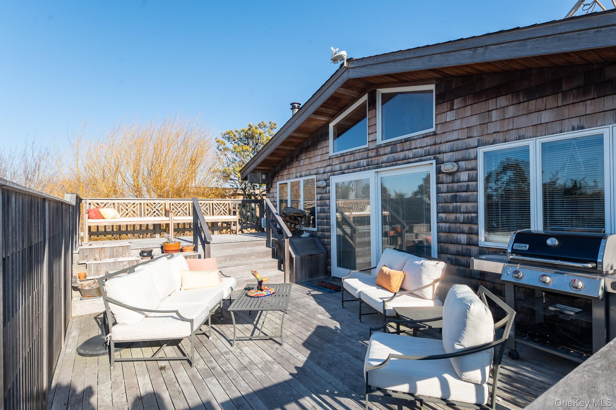 100 Clipper Way Ocean Beach, NY 11770 - Photo 28 of 46 a view of a patio with table and chairs potted plants with wooden floor and fence