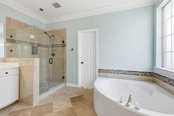 a bathroom with a tub a sink and mirror