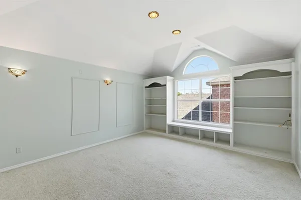 a view of an empty room with a fireplace and a window