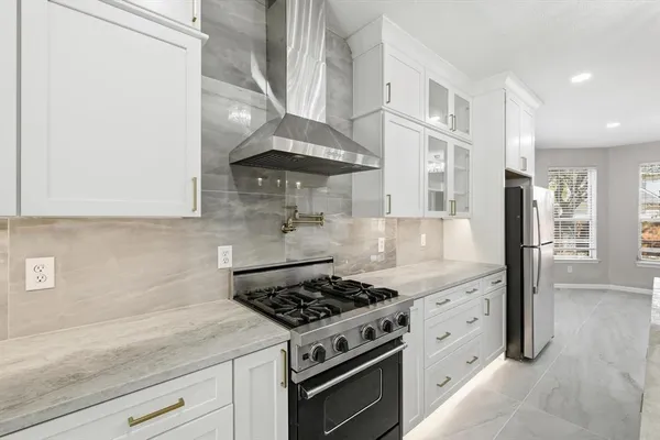 a kitchen with stainless steel appliances granite countertop a sink a stove and a refrigerator