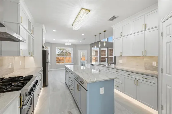 a kitchen with granite countertop a sink stove and cabinets