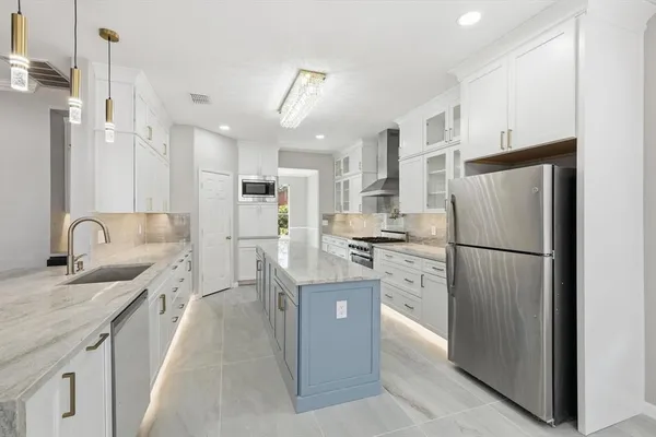 a kitchen with stainless steel appliances granite countertop a refrigerator sink and cabinets