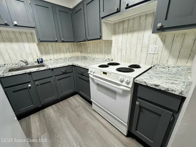 a kitchen with granite countertop wooden cabinets and a sink