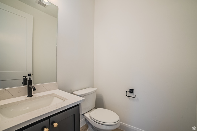45 North Scarlet Maple Road, Unit 4317 Vineyard, UT 84059 - Photo 14 of 35 Modern bathroom featuring a dark grey vanity with gold-tone hardware, an integrated sink with a light-toned countertop, a black faucet, and a wall-mounted mirror