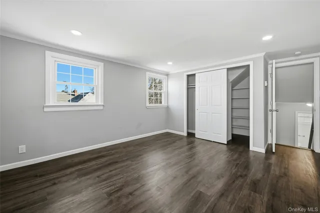 an empty room with wooden floor and closet