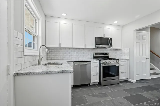 a kitchen with granite countertop a sink and a stove top oven