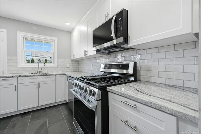 a kitchen with stainless steel appliances granite countertop a stove and a microwave